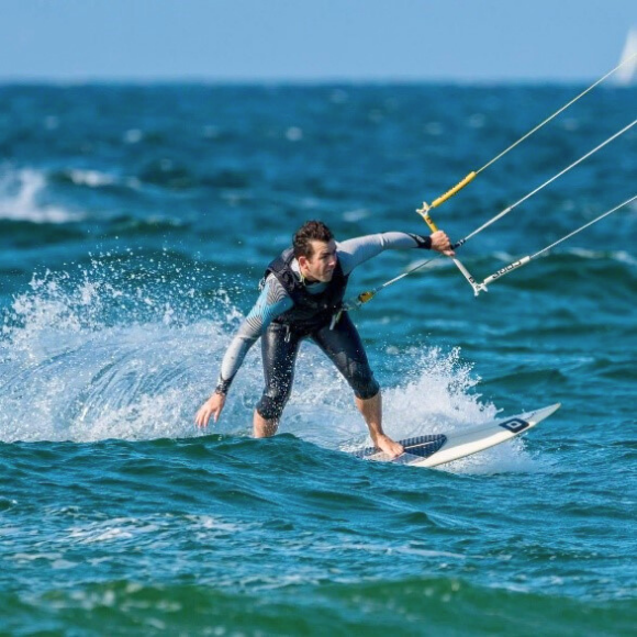 Johannes Vogel kitesurft auf dem Meer.