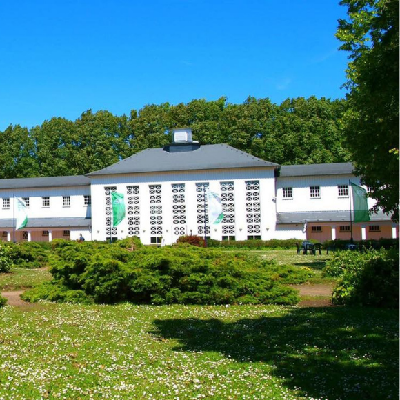 Außenansicht des Klinikgebäudes auf Rügen, eingebettet in eine naturnahe Landschaft.
