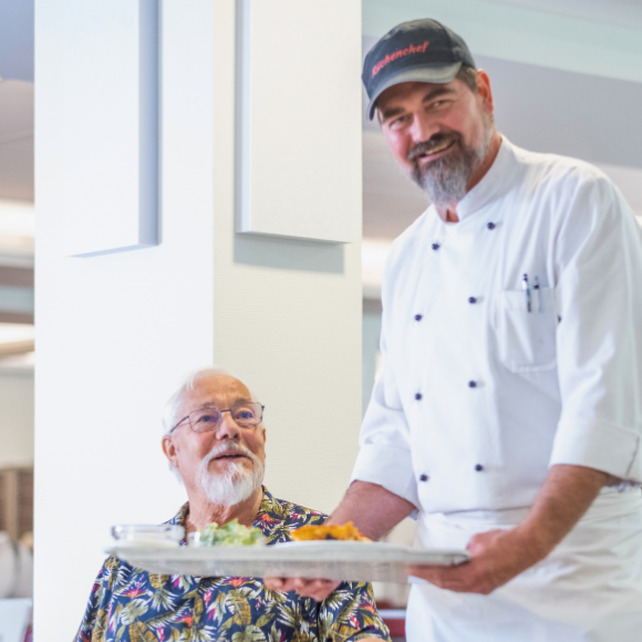 Küchenchef beim Servieren von Essen an einen Patienten